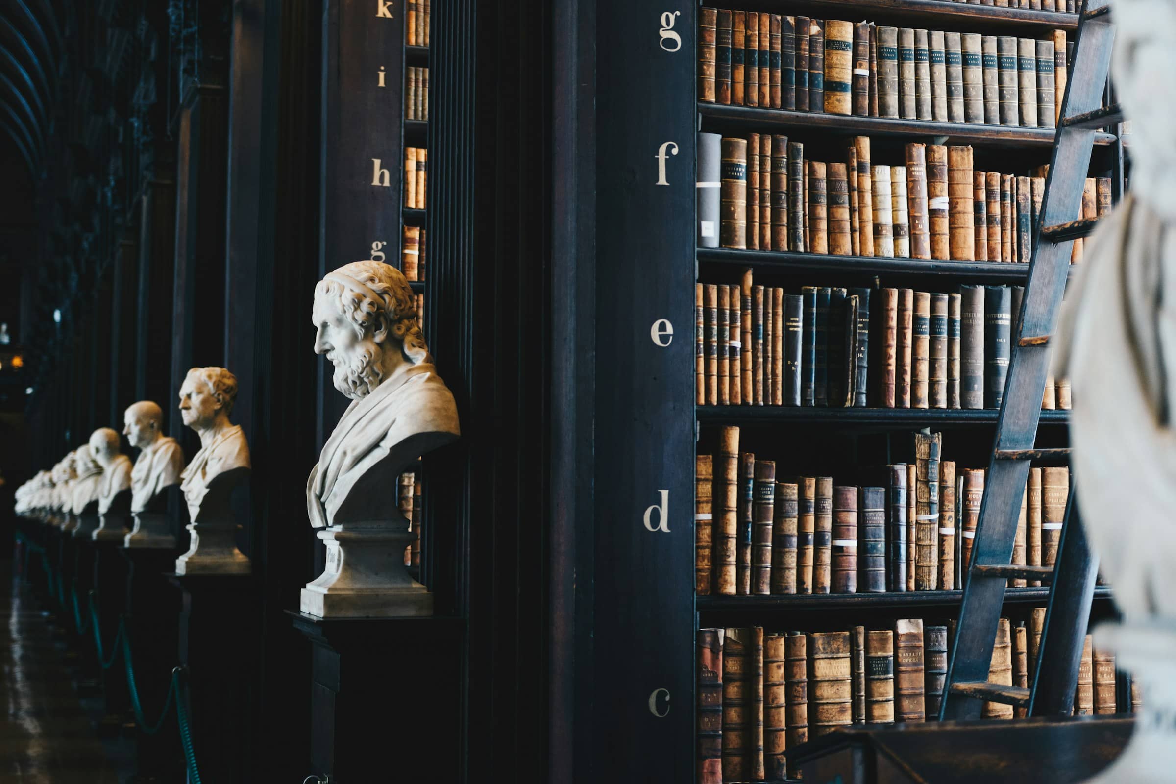 Biblioteca jurídica con bustos y libros antiguos