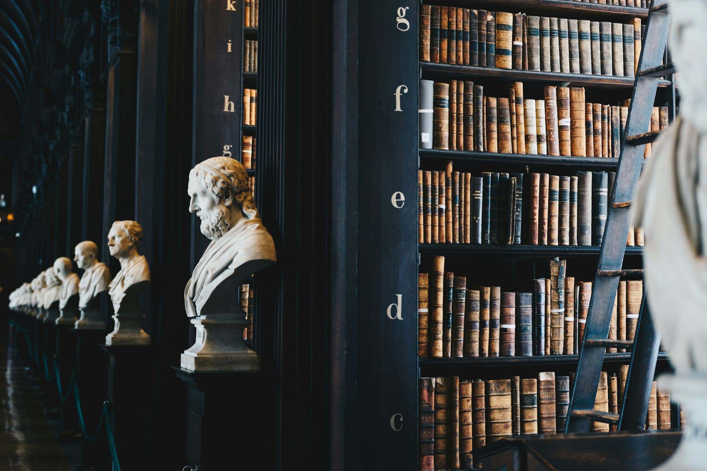 Biblioteca jurídica con bustos y libros antiguos